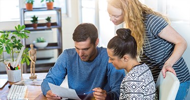 Three people in an office studying a document